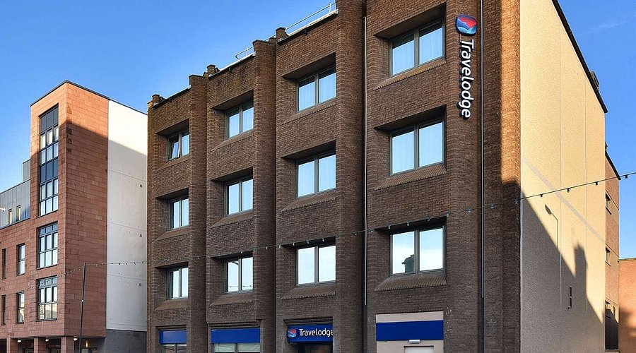 Façade d'un hôtel Travelodge, actif immobilier de rendement en briques brunes.