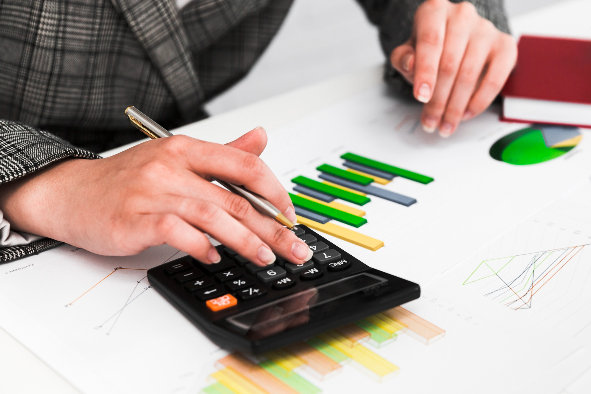 Personne utilisant une calculatrice et des graphiques pour analyser la valeur de réalisation d’une SCPI.